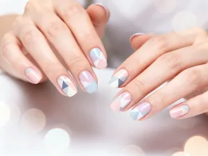Uśmiechnięta kobieta po pięćdziesiątce z modną, cieniowaną fryzurą o dużej objętości w nowoczesnym salonie fryzjerskim.